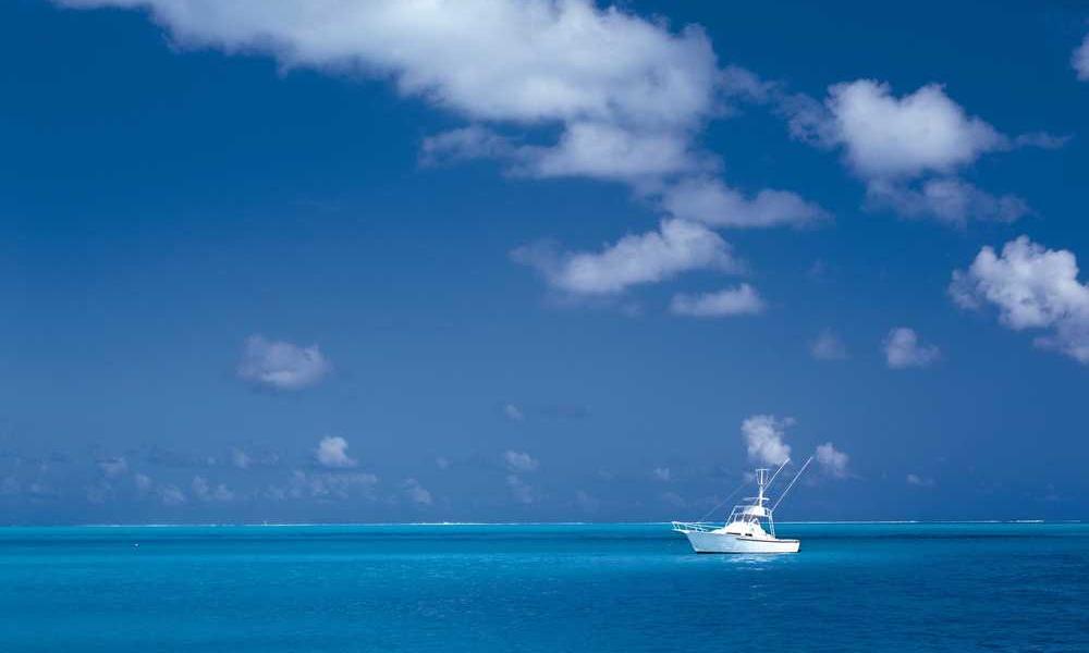 Boot auf ruhigem Wasser unter blauem Himmel mit Wolken