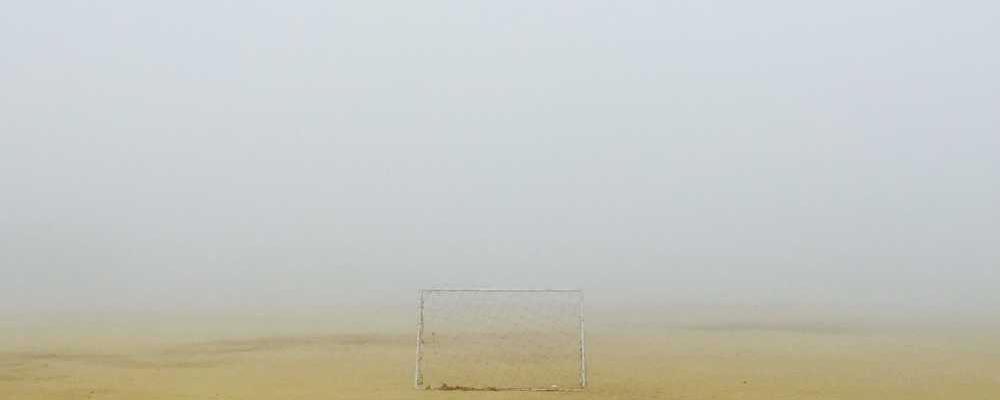 Leeres Fußballtor in nebligem Umfeld, symbolisiert Unsicherheit in der Immobilienbranche, RentPilot