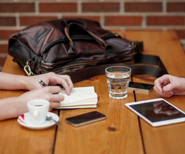 Tischszene mit Notizbuch und Tablet für Immobilienfinanzierung.