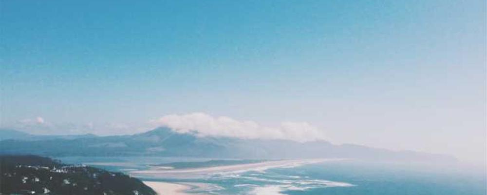 Landschaft mit Küstenlinie und Bergen, ideal für Immobilienverwaltung-Blog.