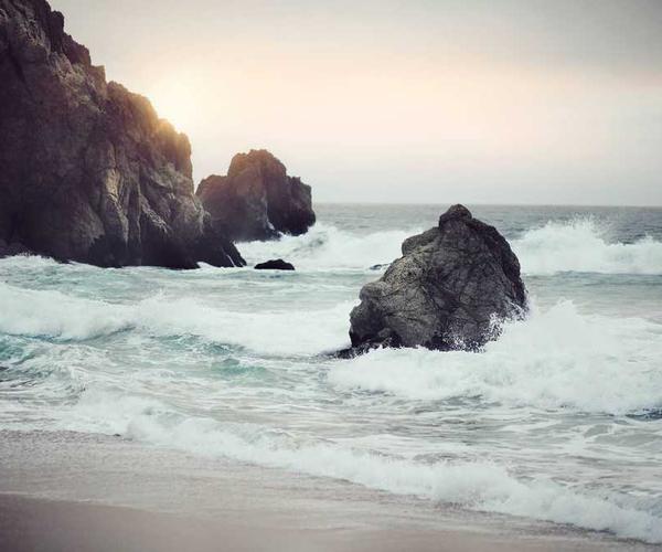 Küstenlandschaft mit Wellen und Sonnenuntergang für Immobilienverwaltung Blog