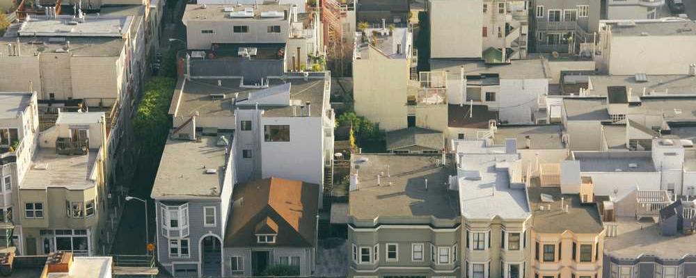 Luftaufnahme urbaner Wohngebäude mit verschiedenen Dachformen und Farben