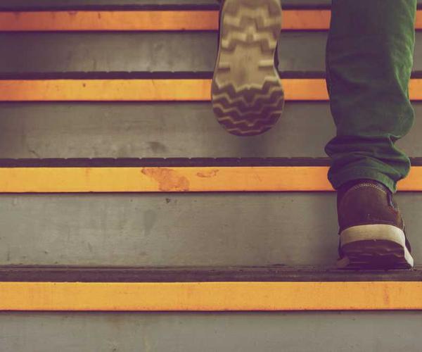 Person mit braunen Schuhen steigt eine Treppe hinauf – RentPilot