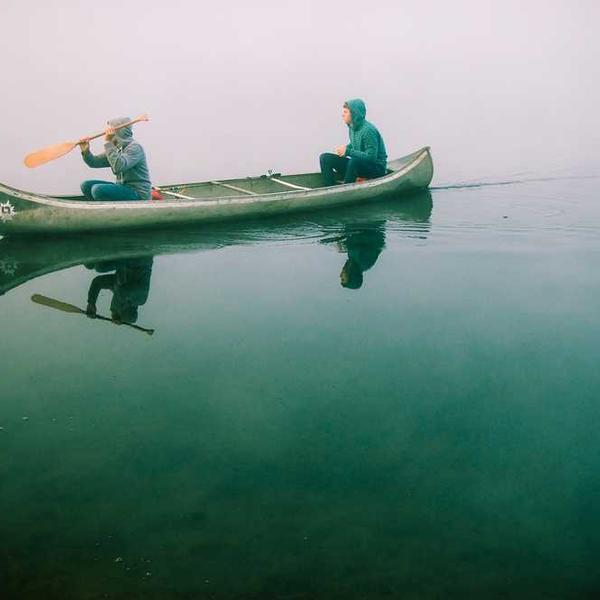 Zwei Personen im Kanu auf einem ruhigen See, RentPilot.
