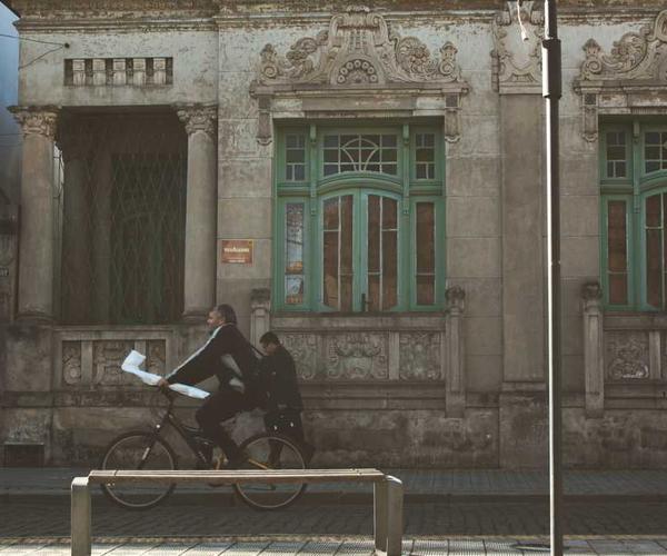 Bicycle rider vor historischem Gebäude in urbaner Umgebung, RentPilot