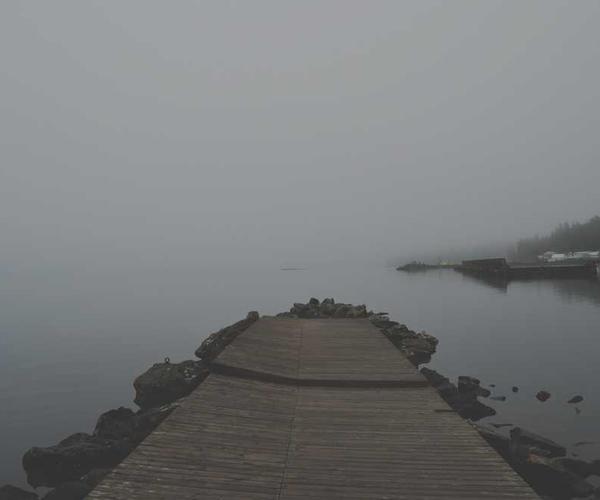 Nebelige Landschaft mit Holzsteg ins Wasser, RentPilot