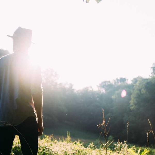 Person im natürlichen Umfeld, blickt nachdenklich in die Landschaft - RentPilot