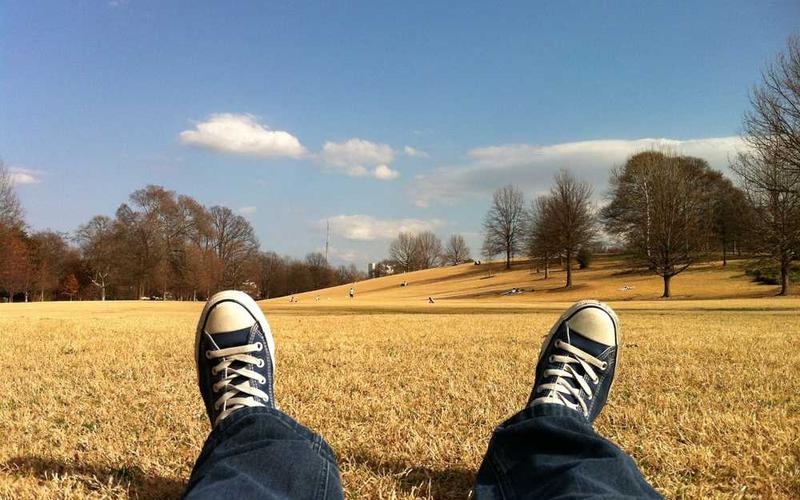 Person entspannt auf Wiese, symbolisiert Entspannung in Immobilienfinanzierung - RentPilot