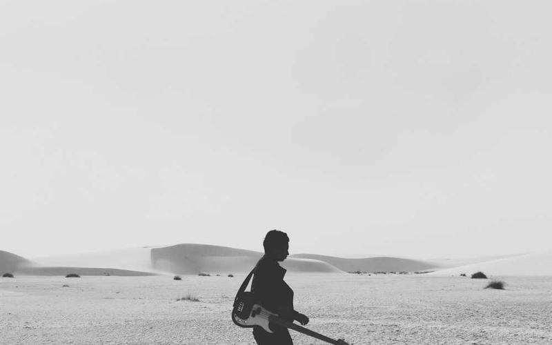 Person in Wüstenlandschaft mit Gitarre für RentPilot Blog