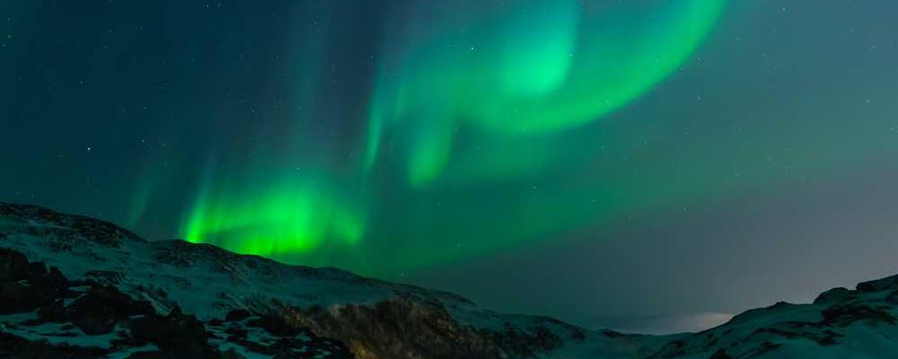 Nordlicht über schneebedeckter Landschaft bei RentPilot