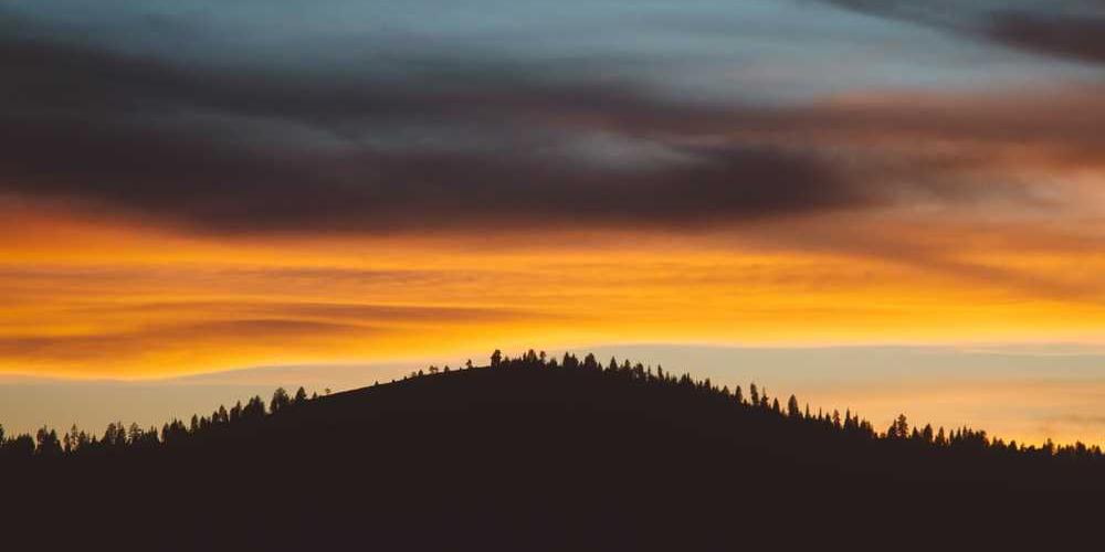 Sonnenuntergang über einer Hügel-Landschaft von RentPilot