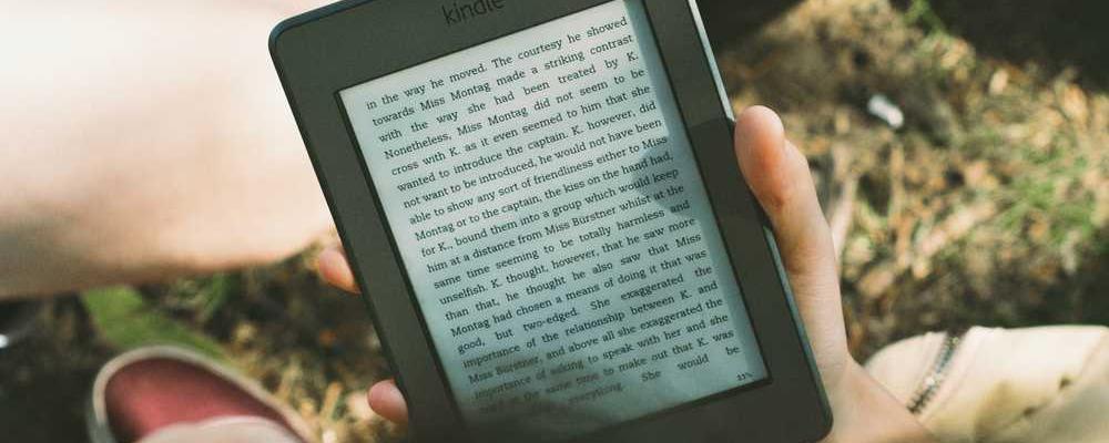 Person hält E-Book, entspanntes Lesen zu Immobilienverwaltung bei RentPilot