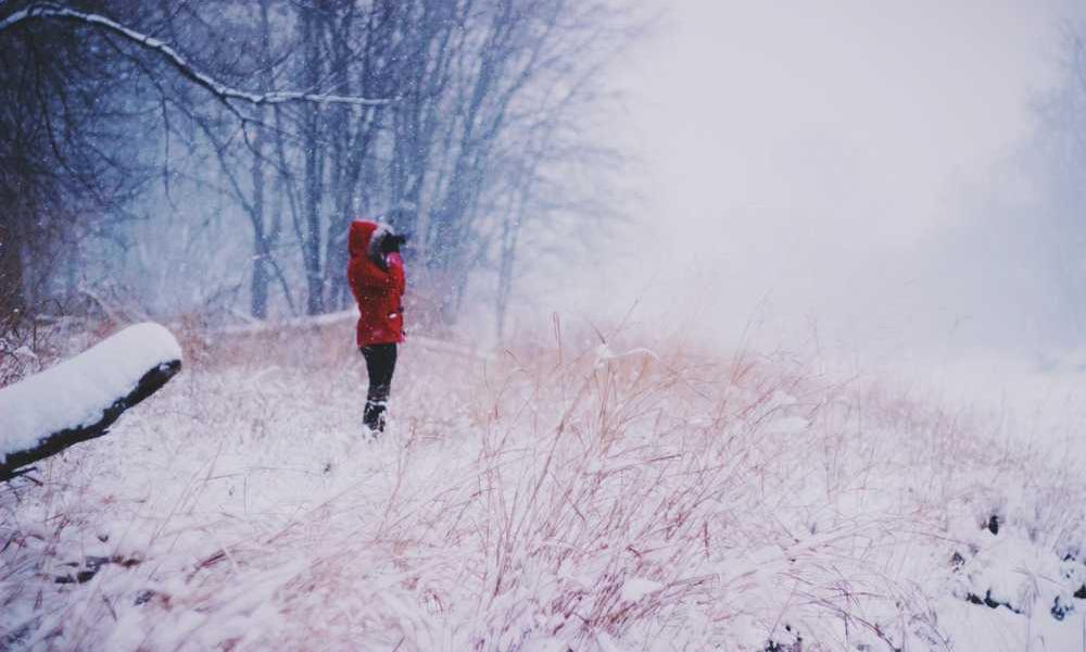 Person im roten Mantel in verschneiter Winterlandschaft für RentPilot