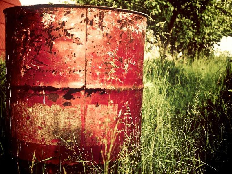 Rostiges rotes Fass in grüner Umgebung, rustikale Nostalgie