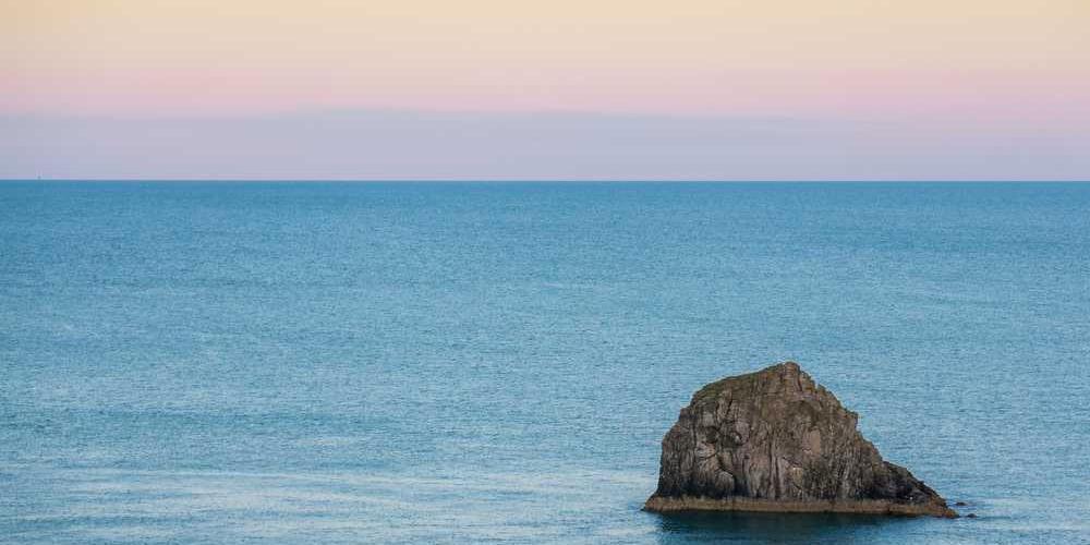 Ruhige Meeresszene mit Felsen, symbolisiert Stabilität in der Immobilienfinanzierung von RentPilot.