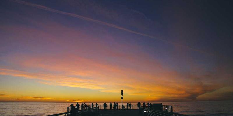 Menschen genießen den Sonnenuntergang am Steg – RentPilot