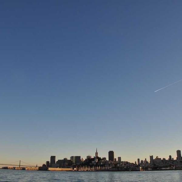 Städtische Landschaft mit Kanal und beleuchteten Gebäuden bei Abenddämmerung - RentPilot