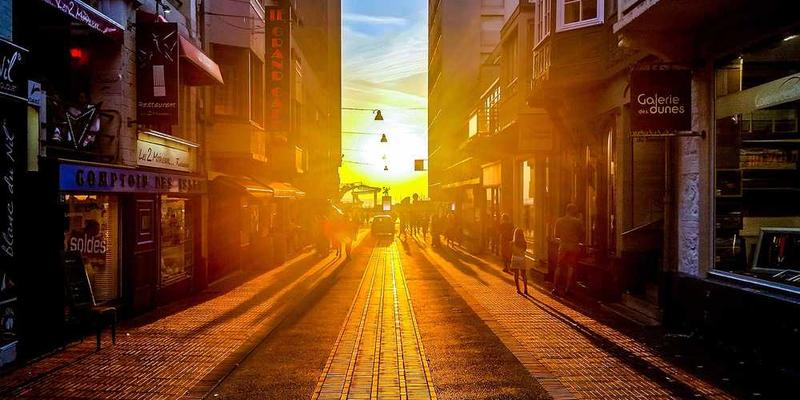 Städtische Straße bei Sonnenuntergang mit Geschäften, RentPilot