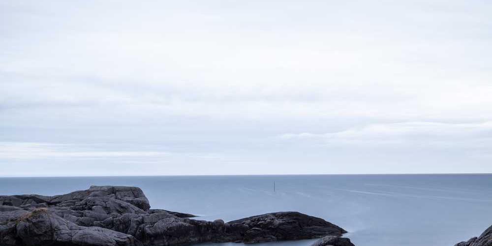 Ruhige Strandlandschaft mit grauen Felsen für RentPilot Blog