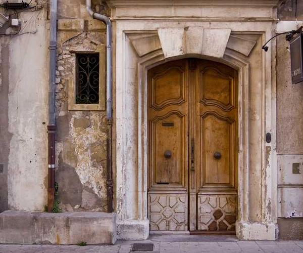 Verwitterte hölzerne Tür in traditionellem Mauerwerk