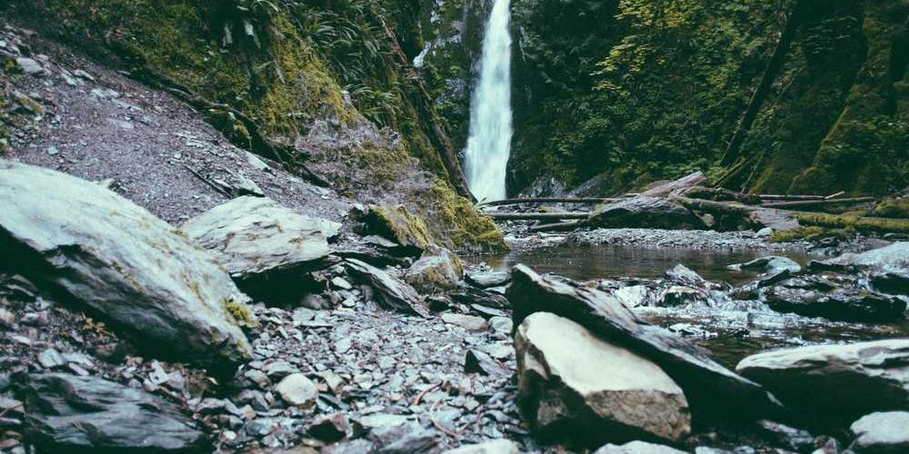 Natürliche Landschaft mit Wasserfall und Steinen, ideal für Facility Management Tipps.